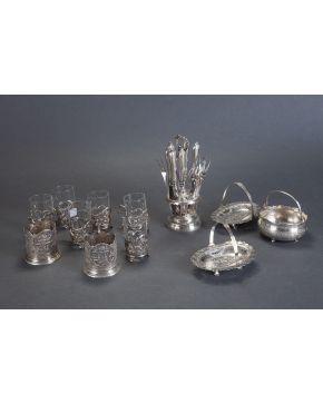 718-Lote para té persa compuesto por: 5 vasos en cristal con monturas en plateado y 2 tazas en plata con decoración repujada y calada. 
