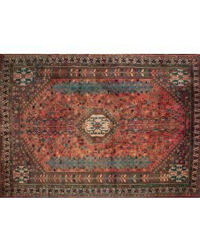 1177-Alfombra persa en lana con decoración vegetal y geométrica sobre campo rosáceo. Colores complementarios: marrón. verde y azul.