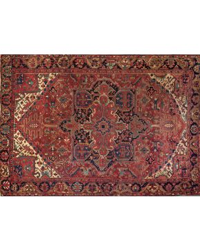 804-Interesante alfombra persa Heriz en lana con profusa decoración vegetal sobre campo granate. Colores complementarios: verde. azul y marrón.