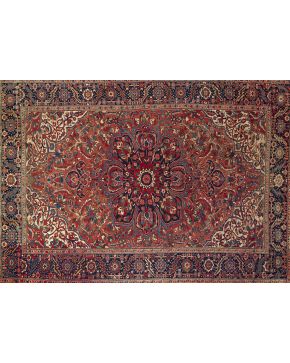 836-Antigua alfombra persa persa Ghoravan en lana con florón central con decoración vegetal sobre campo granate y cenefa en azul oscuro. 
