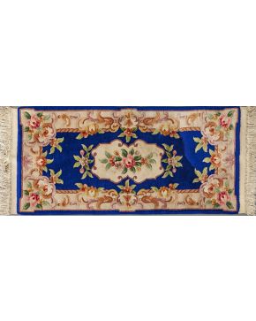 1329-Juego de tres alfombras en lana chinas con decoración floral sobre campo azul.
