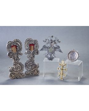 1012-Lote de dos objetos devocionales. España s. XVII-XVIII: Medallón en plata con Virgen y Niño (anverso) y Santa (reverso) y cruz de Caravaca en bronce.