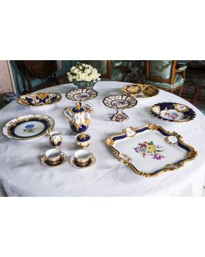 872-Bandeja cuadrada en porcelana de Meissen en blanco y azul cobalto con decoración esmaltada de flores. filos y esquinas con conchas en dorado. Con marc