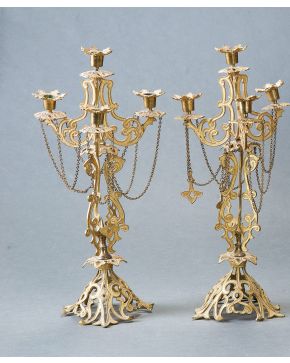 3040-Pareja de candelabros de cinco luces en bronce dorado. S. XIX. Estructura calada de bellas formas geométricas ojivales. Decoración aplicada de cadenet