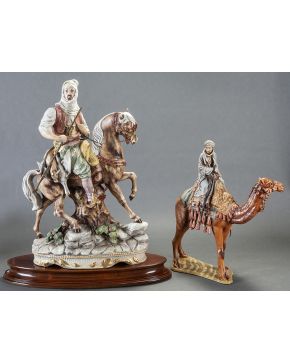 934-Lote de dos figuras de árabes: la menor en porcelana esmaltada y decorada a mano de la Fundación de Gremios. España. s. XX; la más grande en porcela