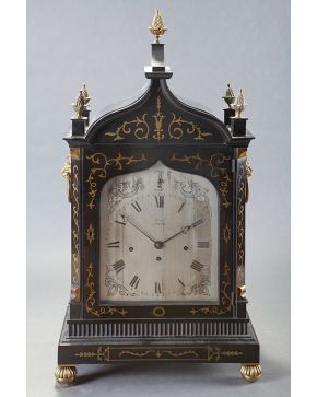 561-Gran reloj bracket ingles en con caja en madera tallada con incrustaciones en latón. asas en cabeza de león con argolla y remates de piñas. Esfera fir