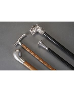 552-Lote de dos bastones en madera clara con empuñadura en plata. uno de ellos con punzones y el otro con trabajo martelé e iniciales.