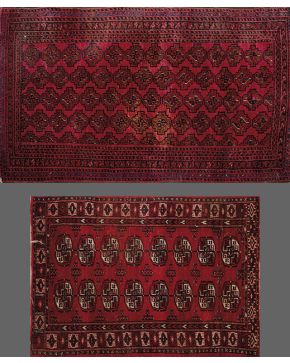 887-Lote de dos alfombras persas con campos granates y decoración en negro.