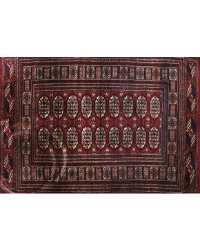 1000-Lote de dos alfombras persas en lana con decoración geométrica en negro sobre fondos rojo y granate.