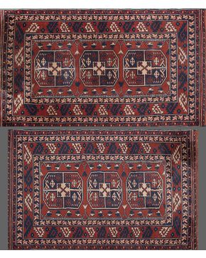 1129-Lote de dos alfombras persas en lana. Decoración geométrica en azul y crema sobre fondo granate.