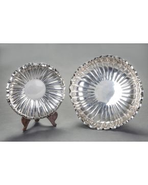 513-Lote de dos bandejas circulares de diferentes tamaños de formas gallonadas y perfil polilobulado en plata española punzonada con marcas de Agruña.