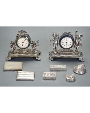 549-Reloj de sobremesa en plata española. Sobre cuatro patitas. con pareja de amorcillos y palomas en remate.