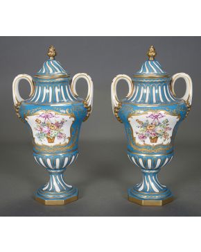674-Pareja de jarrones con tapa en porcelana de París con decoración de flores en reserva sobre fondo azul. c.1900. Con marcas. Algún desperfecto.