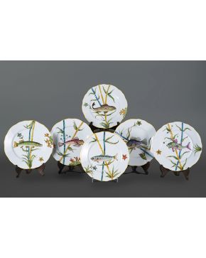798-Decorativa vajilla en porcelana de Limoges con decoración pintada a mano de peces. filo en amarillo. Se compone de 6 platos llanos. Marcas en la base: