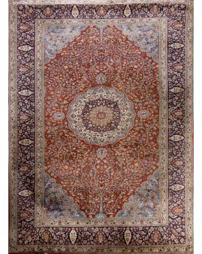 334-Alfombra persa en lana sobre campo granate con florón central. profusa decoración vegetal y representación del árbol de la vida. Cenefa en azul oscuro