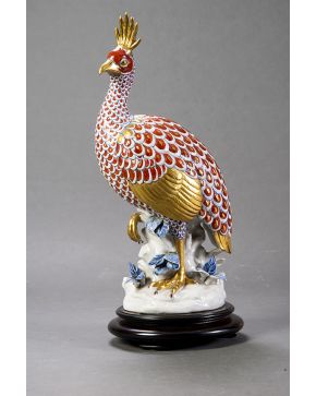 1025-Gallina de Guinea o gallina pintada en porcelana esmaltada de Capodimonte. Sobre peana de madera. Con marcas. 