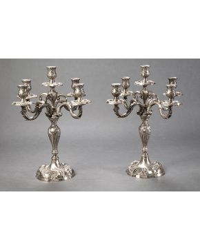 785-Pareja de candelabros de cinco luces en plata española punzonada con decoración relevada de tornapuntas. rocallas y flores.