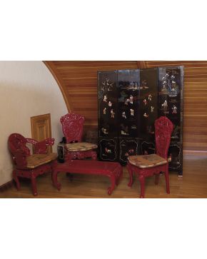 421-Juego de mobiliario oriental en laca color rojo formado por: mesa centro rectangular. dos sillas y butaca con brazos terminados en cabeza de dragón.  