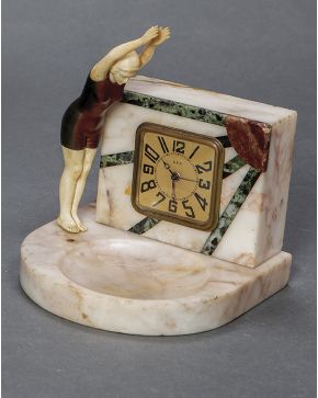 465-Reloj de sobremesa Art Decó. C. 1920. En mármoles de distintos colores con bañista en márfil y bronce pavonado.