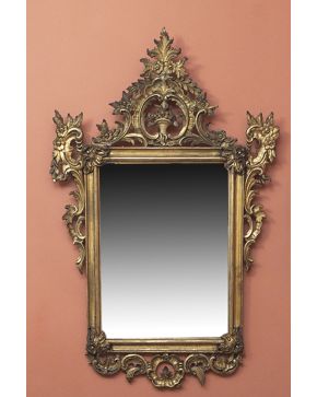 567-Espejo con marco en madera tallada y dorada con decoración de tornapuntas. rocallas y flores. S. XVIII.