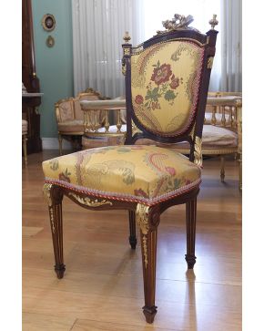 680-Elegante silla estilo neoclásico en madera tallada de caoba y dorada. Remate de antorchas y carcaj. Tapicería de seda amarilla con decoración de flore