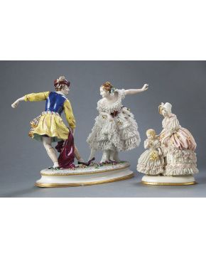 546-Lote en porcelana centroeuropea formado por dos grupos: pareja de baile y dama con niña. Aplicaciones de flores y encajes. Principios s. XX. Con m