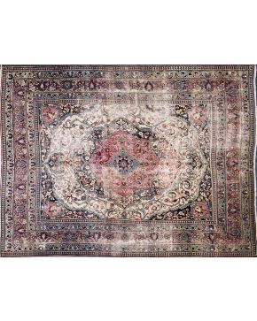 431-Alfombra persa en lana con profusa decoración vegetal sobre campo rosado y cenefas en granate y verde. Desgastes.
