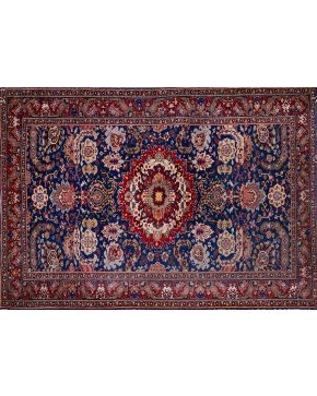 420-Alfombra persa en lana con decoración geométrica y vegetal esquematizada sobre campo azul marino y cenefa en granate. 