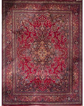 578-Alfombra persa en lana con decoración geométrica y vegetal sobre campo granate.