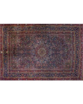 311-Gran alfombra Sharc antigua en lana con profusa decoración vegetal y floral con rosetón y centro polilobulado sobre campo granate. Colores complemen