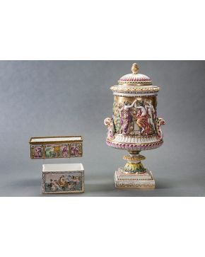 506-Lote en porcelana polícroma de Capodimonte formado por dos cajitas. una representando El Triunfo de Anfítrite. y copa con tapa y figuras en relieve 