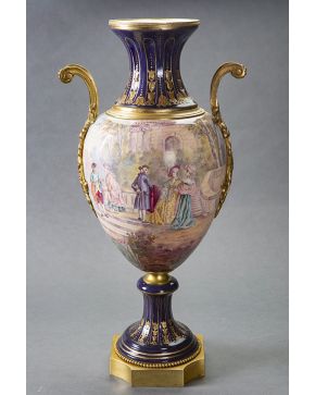 533-Gran jarrón en porcelana de Sévres azul cobalto con montura y asas en bronce dorado. Escena dieciochesca en el cuerpo. firmada. y detalles en dorado. 