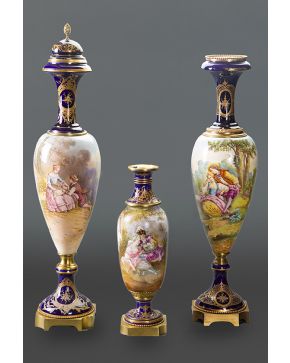 576-Lote de tres jarrones en porcelana de Sévres. uno de ellos con tapa. Monturas en bronce y detalles en dorado y escenas esmaltadas en el cuerpo. firmad