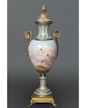 560-Jarrón con asas y tapa en porcelana de Sévres azul celeste con escena esmaltada en el cuerpo y monturas en bronce dorado. Desperfectos.