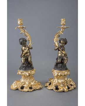 441-Importante pareja de candeleros estilo Luis XV en bronce dorado y pavonado siguiendo modelos de Clodión. Fustes con pequeños Bacos. Bases y candeleros