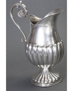 355-Jarra en plata española punzonada con marcas de Agruña. Formas gallonadas y asa con forma de tronapunta. Alguna abolladura.