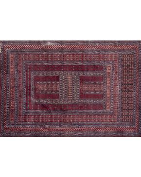 589-Alfombra persa en lana con decoración geométrica y vegetal sobre campo granate. 