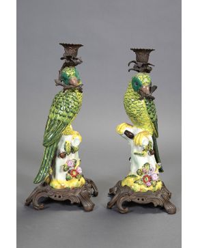 609-Pareja de candeleros con fustes de loros en rama en loza esmaltada de alegre colorido. Con monturas en bronce dorado. C. 1900.