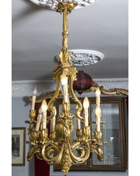 707-Exquisita lámpara estilo Luis XV en bronce dorado de 9 luces. Decoración vegetal. de rocallas y lazo.