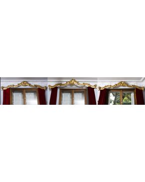 709-Conjunto de tres galerías estilo Luis XV en madera tallada y dorada. decoración vegetal entrelazada con cortinas de terciopelo rojo.