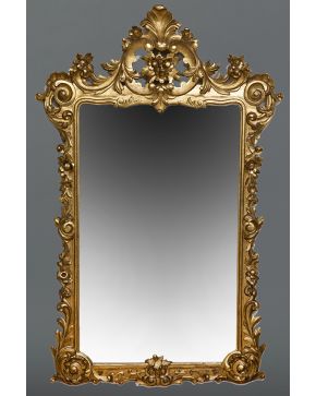 717-Gran espejo estilo Luis XV en madera tallada y dorada con copete de flores y palmetas