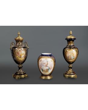 1115-Lote en porcelana de Sévres formado por tres piezas: dos jarrones con tapa y otro globular más bajo. En azul cobalto y dorado con escenas esmaltadas e