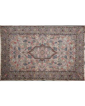 1028-Alfombra persa en lana sobre campo beige con representación de arcos polilobulados y decoración floral y vegetal en tonos rosas. marrones y azules. 