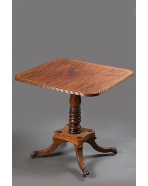 570-Mesa auxiliar estilo inglés en madera de caoba con pie torneado y cuatro patitas termiandas en garras de bronce sobre rueda.