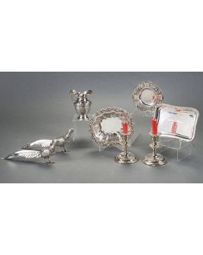 637-Variado lote en plata formado por tres bandejitas de diferentes formas y tamaños y pareja de pequeños candeleros. Una pieza con marcas de Montejo.