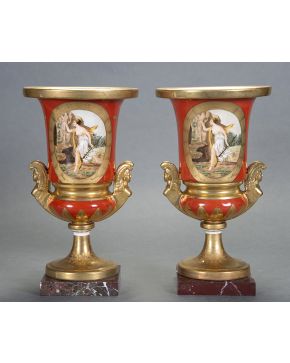 1049-Pareja de copas en porcelana Viejo París. Bases en mármol veteado. esmaltadas. con esfinges aladas a modo de asas y personajes mitológicos en reserv