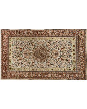 537-Alfombra persa en lana con profusa decoración vegetal sobree campo marrón.