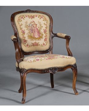 1298-Butaca estilo Luis XV. En madera tallada en su color con tapicería floral.