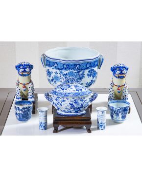 892-Lote en porcelana blanca y azul (algunas piezas orientales y otras de Delft) compuesto por: sopera con tapa en miniatura sobre peana en madera. dos pe