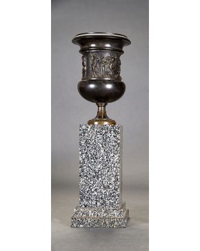 691-Copa clásica en bronce pavonado con friso con decoración en relieve de escena báquica. Sobre peana de granito gris. 